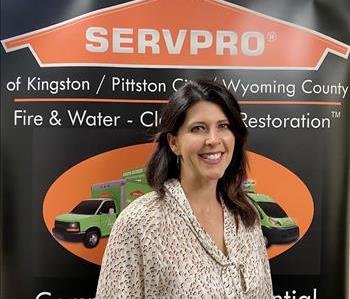 Female SERVPRO rep in front of SERVPRO sign
