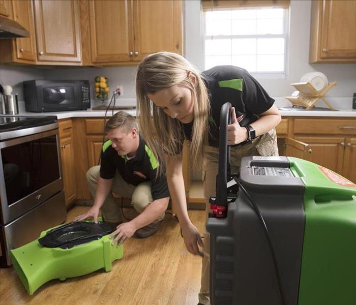 Servpro technicians setting equipment in kitchen with water damage